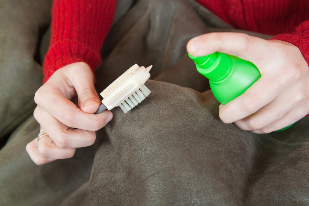 woman cleaning sheepskin with whisk broom