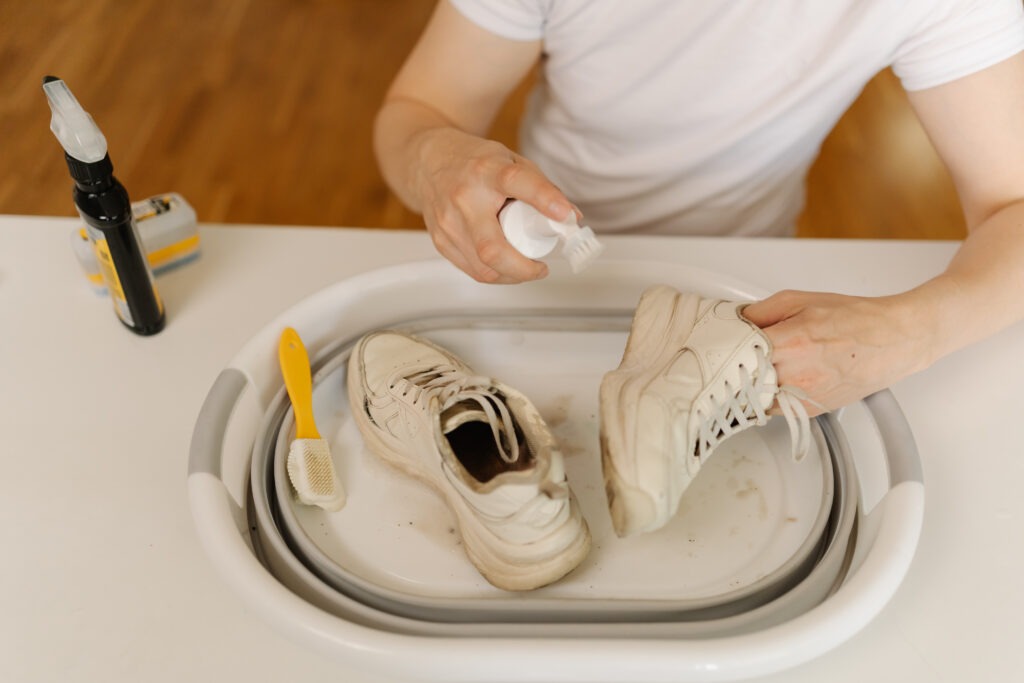 highangle view cleaning white sneakers with scrubbing brush detergent removing stubborn
